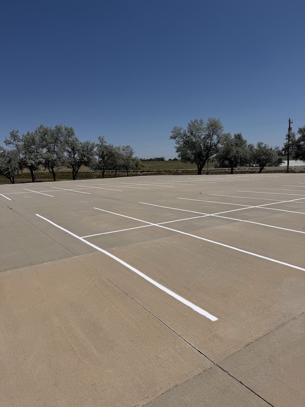 Newly restriped white parking lines on a church lot, taped off with caution tape